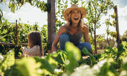 A family gardening and smiling